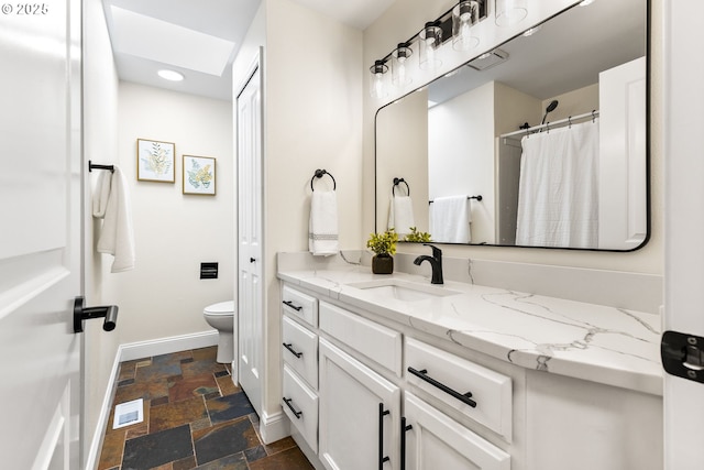 full bathroom featuring recessed lighting, vanity, stone tile floors, toilet, and baseboards