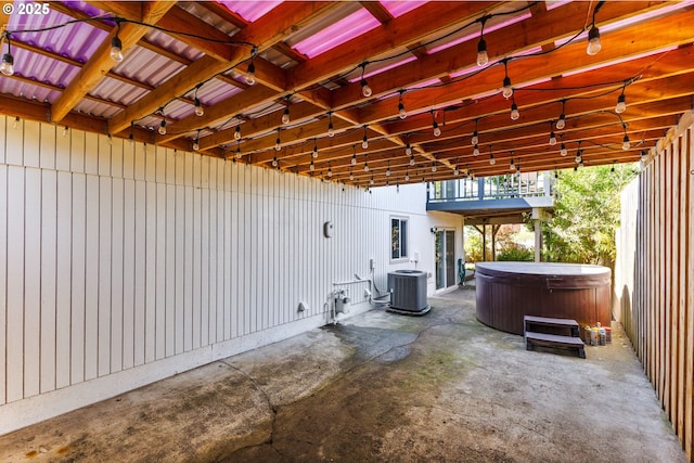 view of patio featuring cooling unit and a hot tub