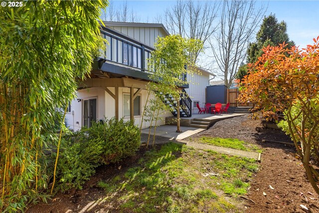 view of yard featuring a deck, fence, stairs, and a patio area