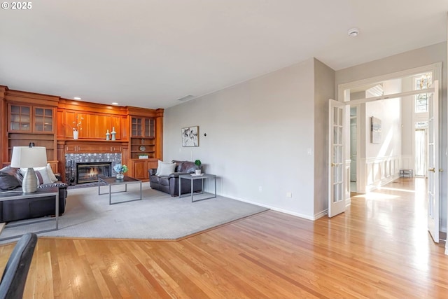 living room with a fireplace and light wood-type flooring