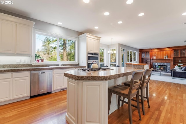 kitchen featuring hanging light fixtures, appliances with stainless steel finishes, sink, and white cabinets