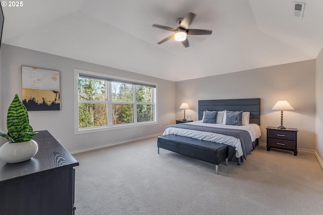 carpeted bedroom with lofted ceiling, a raised ceiling, and ceiling fan