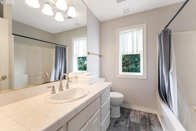 full bathroom with shower / tub combo, vanity, hardwood / wood-style floors, and a wealth of natural light