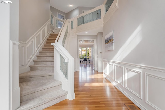 stairs featuring hardwood / wood-style flooring and a chandelier