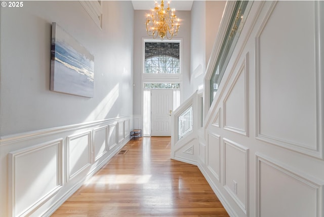 entryway with light hardwood / wood-style flooring and a notable chandelier