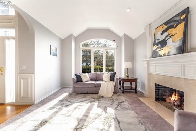 sitting room featuring vaulted ceiling and a tile fireplace