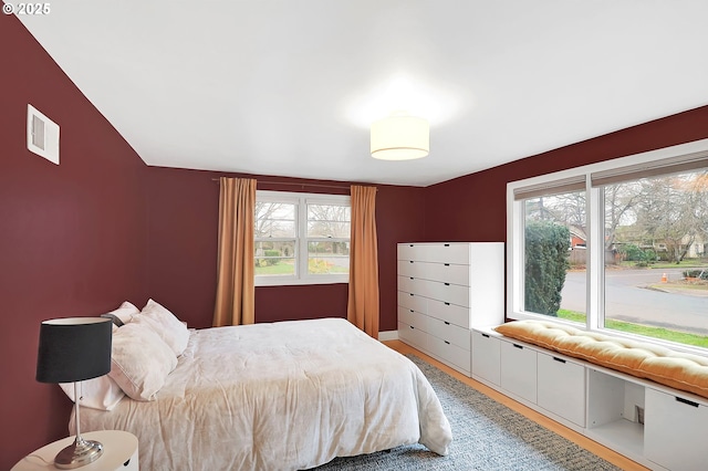 bedroom with hardwood / wood-style flooring and multiple windows