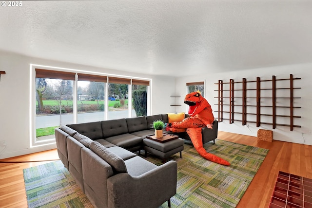 living room featuring wood-type flooring, plenty of natural light, and a textured ceiling