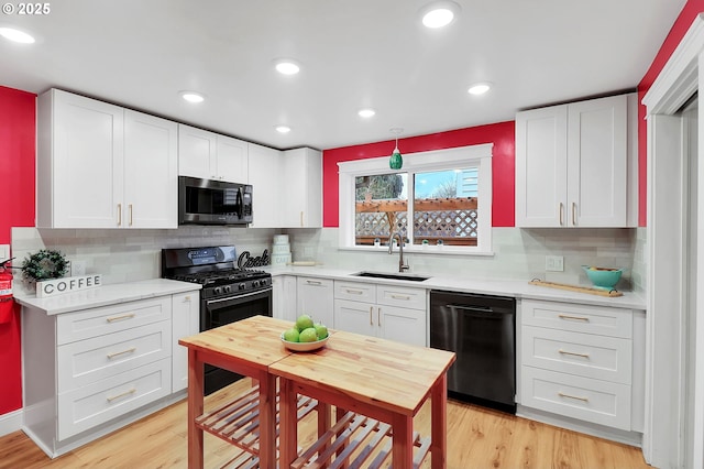 kitchen featuring white cabinetry, sink, and black appliances