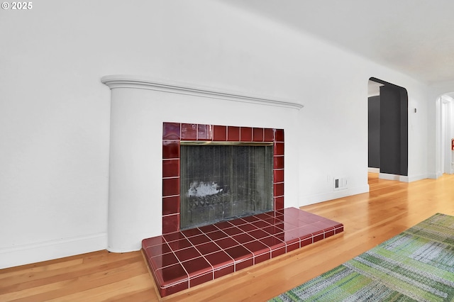 details with hardwood / wood-style floors and a tile fireplace