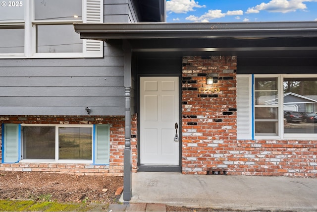 doorway to property featuring brick siding