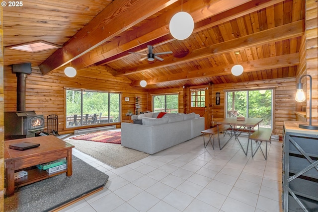 22190 E Lolo Pass Rd, Rhododendron, OR 97049 - living room with a baseboard heating unit, a wood stove, tile patterned floors, wooden ceiling with exposed beams, and a ceiling fan