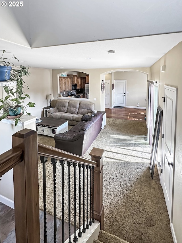 living room featuring baseboards and arched walkways