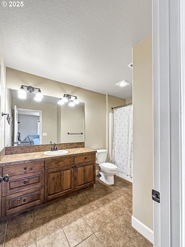 full bath featuring baseboards, toilet, vanity, and a textured ceiling