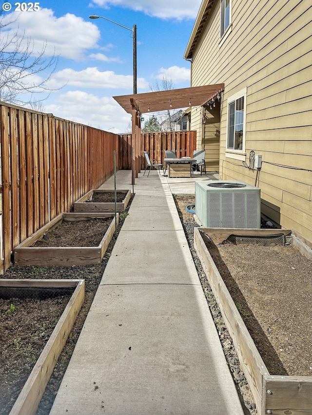 view of yard with central AC unit, a vegetable garden, and a fenced backyard