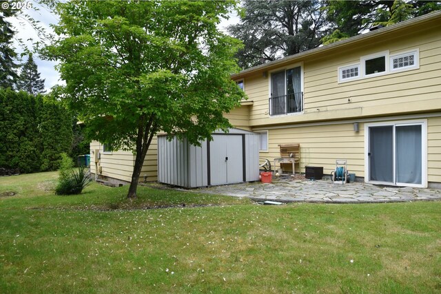 8302 SW 65th Ave, Portland, OR 97219 - rear view of house featuring a storage unit, a patio, a yard, and an outbuilding