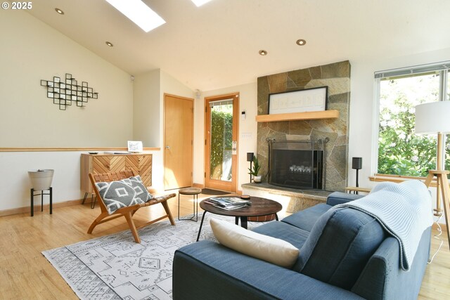 8302 SW 65th Ave, Portland, OR 97219 - living room with wood finished floors, a stone fireplace, lofted ceiling, baseboards, and recessed lighting