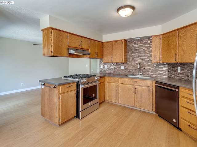 5367 NW 180th Pl, Portland, OR 97229 - kitchen featuring appliances with stainless steel finishes, under cabinet range hood, light wood-style flooring, dark countertops, and backsplash