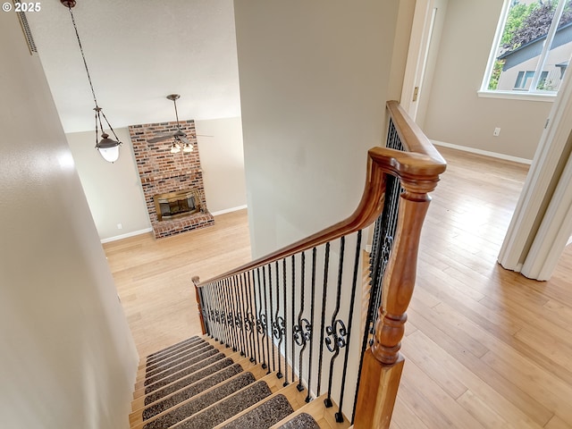 5367 NW 180th Pl, Portland, OR 97229 - staircase with wood finished floors, a ceiling fan, and a fireplace