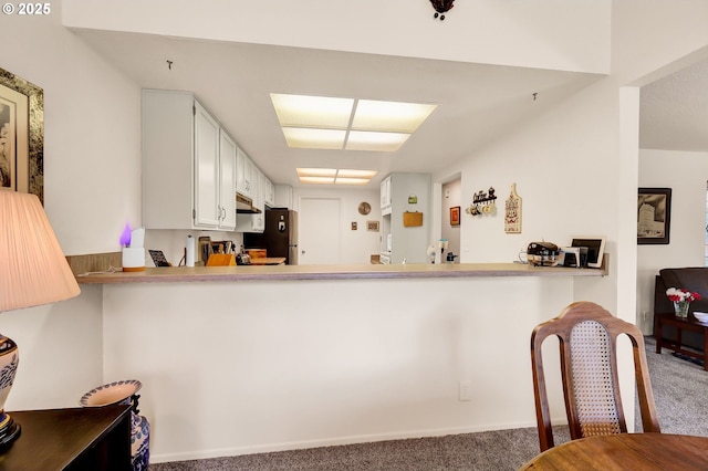 2062 Lake Isle Dr, Eugene, OR 97401 - kitchen with carpet, under cabinet range hood, a peninsula, and freestanding refrigerator