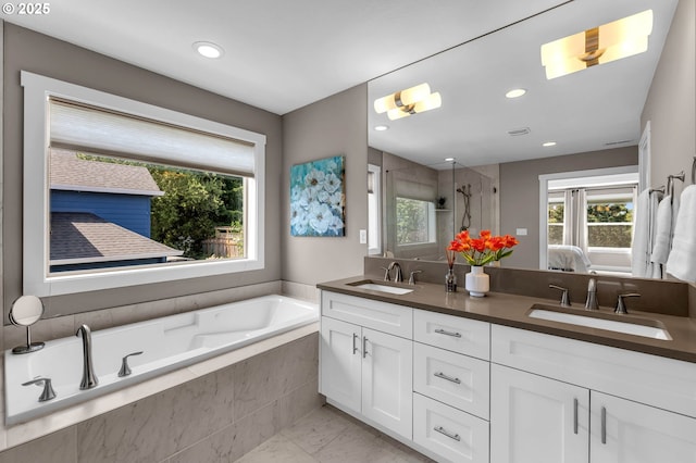 bathroom featuring a shower stall, double vanity, a garden tub, recessed lighting, and ensuite bath