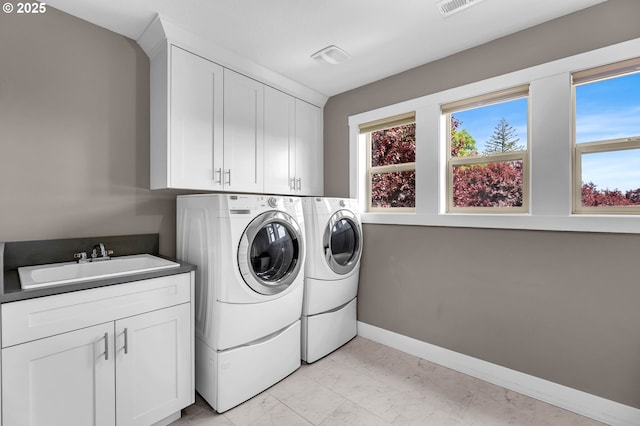 washroom with washer and dryer, cabinet space, light marble finish floors, and baseboards