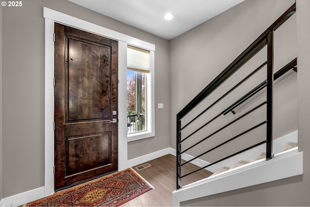 foyer entrance with stairway, dark wood-style flooring, baseboards, and recessed lighting