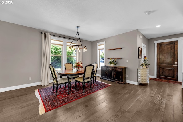 dining room featuring a chandelier, dark wood-style flooring, baseboards, and recessed lighting