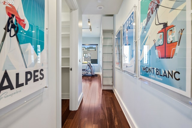 hallway with baseboards and dark wood-type flooring