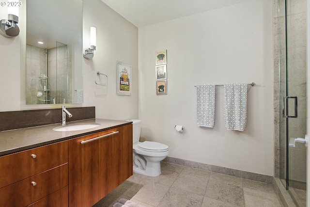 bathroom featuring vanity, toilet, baseboards, and a shower stall