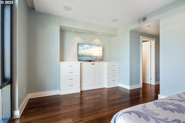 bedroom with dark wood-style flooring, baseboards, and visible vents