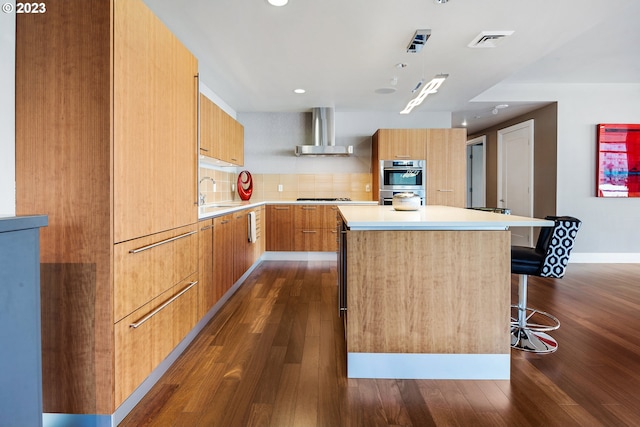 kitchen with a center island, modern cabinets, dark wood finished floors, wall chimney exhaust hood, and stainless steel appliances