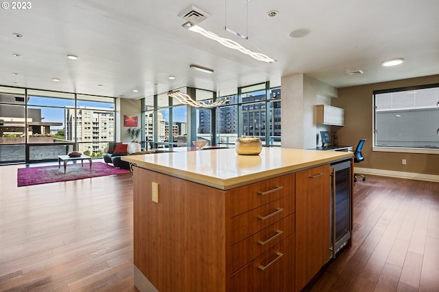 kitchen featuring floor to ceiling windows, dark wood-style floors, open floor plan, and wine cooler