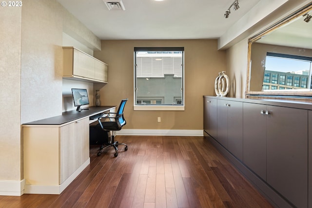 office space featuring built in study area, dark wood-style flooring, baseboards, and visible vents