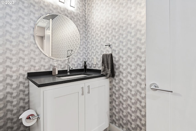 bathroom featuring vanity and wallpapered walls