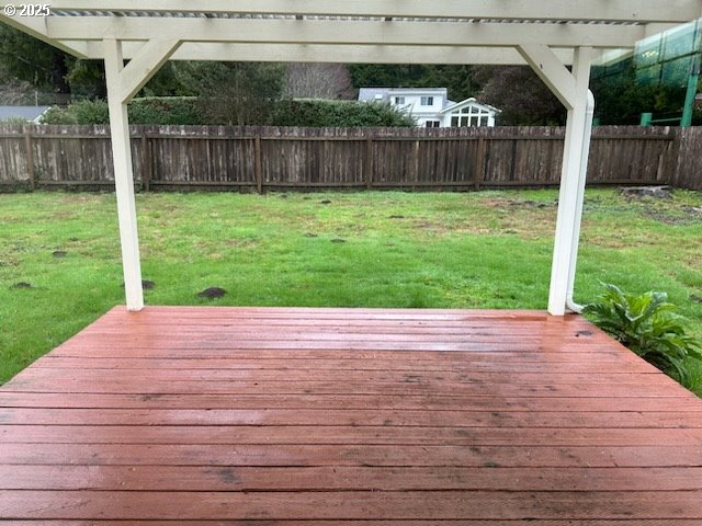 wooden terrace with a lawn and a pergola