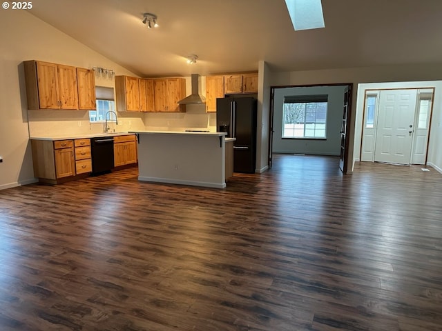 kitchen featuring black appliances, wall chimney range hood, vaulted ceiling with skylight, a kitchen island, and dark hardwood / wood-style flooring