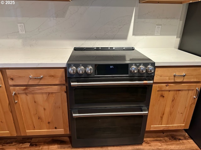 kitchen featuring dark hardwood / wood-style flooring, stainless steel stove, and tasteful backsplash