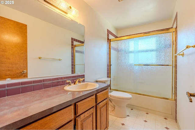 975 SW Florence Ct, Gresham, OR 97080 - bathroom with toilet, vanity, bath / shower combo with glass door, backsplash, and tile patterned flooring