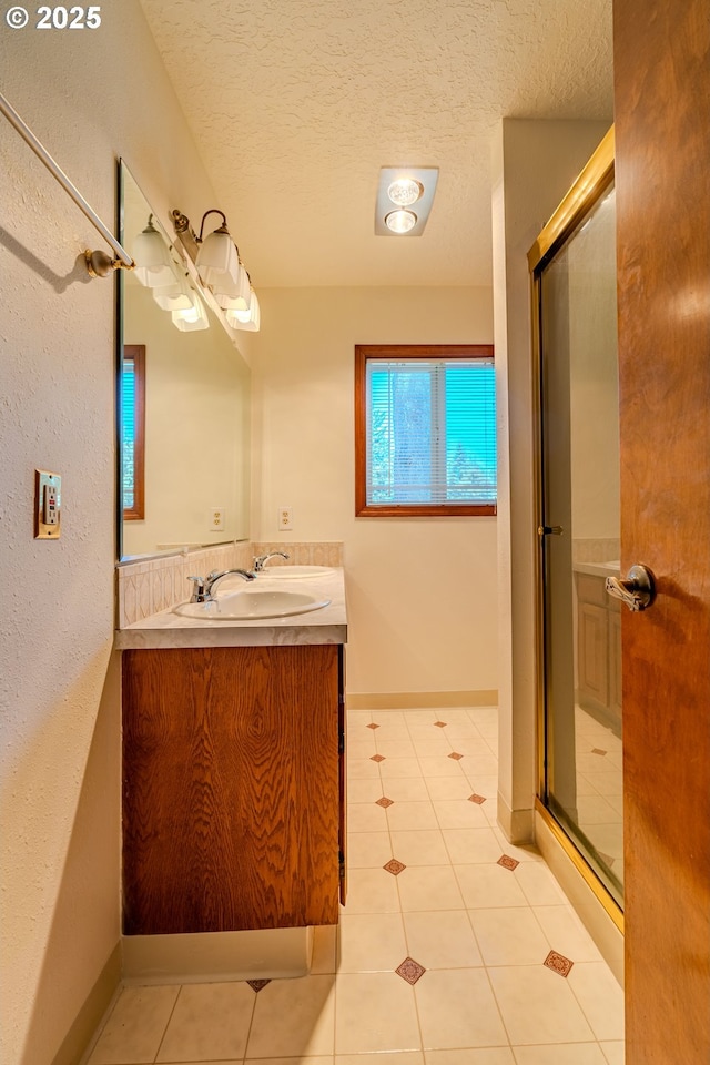 975 SW Florence Ct, Gresham, OR 97080 - full bathroom with vanity, a textured ceiling, a shower stall, tile patterned flooring, and baseboards