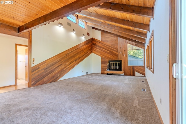 975 SW Florence Ct, Gresham, OR 97080 - unfurnished living room with wood ceiling with exposed beams, carpet floors, wood walls, and a glass covered fireplace