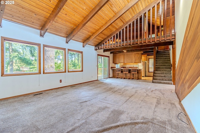 975 SW Florence Ct, Gresham, OR 97080 - unfurnished living room with high vaulted ceiling, light carpet, wooden ceiling with exposed beams, stairs, and baseboards