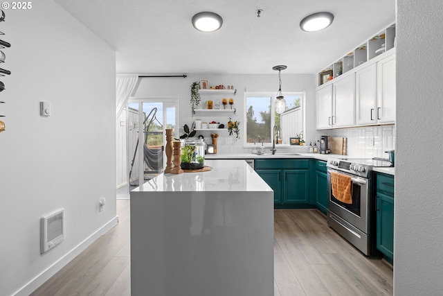 kitchen featuring open shelves, stainless steel electric range oven, backsplash, and a sink