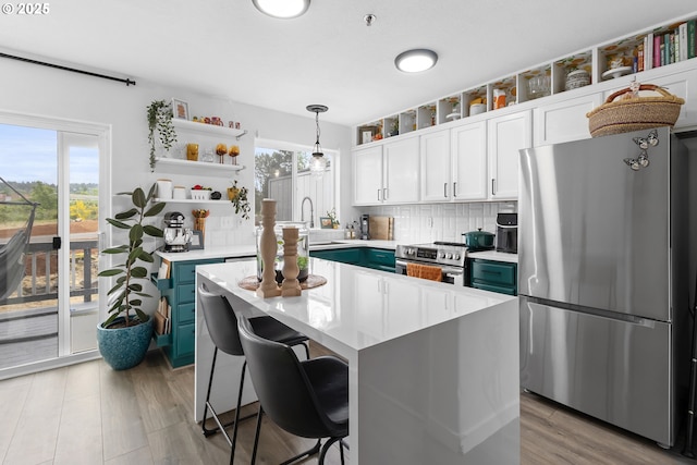 kitchen featuring appliances with stainless steel finishes, open shelves, light countertops, white cabinetry, and decorative backsplash