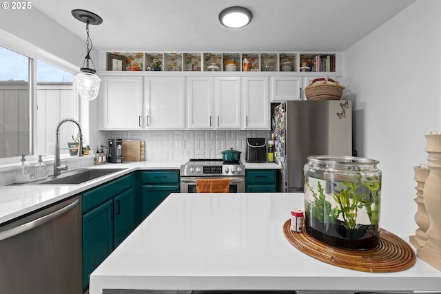 kitchen featuring appliances with stainless steel finishes, a sink, light countertops, and white cabinets