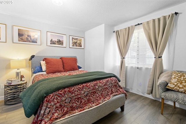 bedroom featuring wood finished floors and a textured ceiling