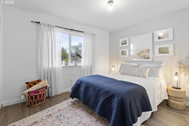 bedroom featuring wood finished floors and baseboards