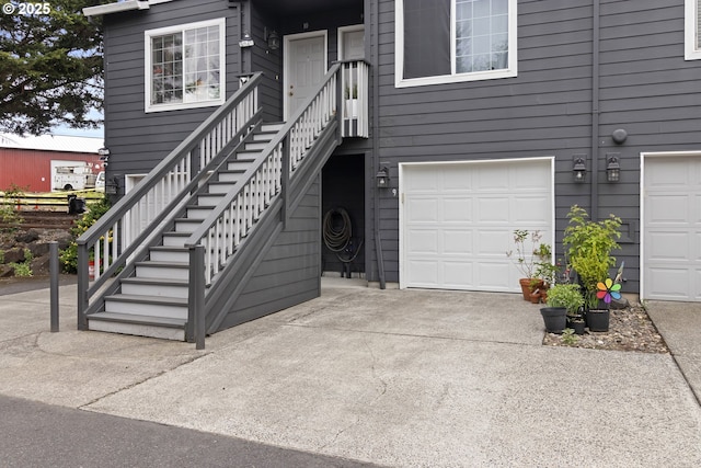 entrance to property featuring concrete driveway and a garage