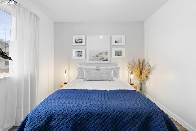 bedroom featuring wood finished floors and baseboards