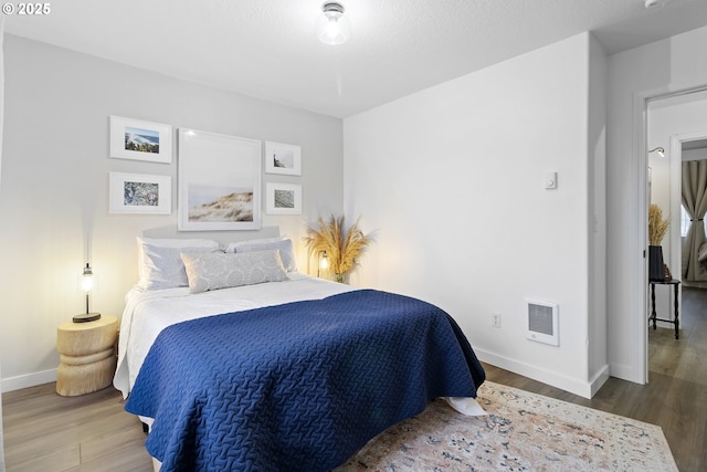bedroom featuring wood finished floors and baseboards